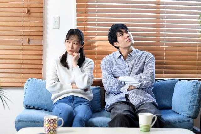 遺品整理を誰がやるべきか悩む夫婦のイメージ